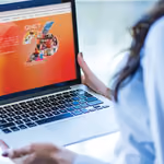 QNET’in websitesini görüntüleyen laptop görseli