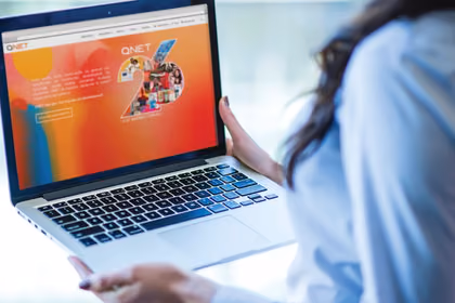 QNET’in websitesini görüntüleyen laptop görseli