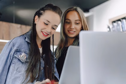 İki genç kadın influencer, sosyal medya üzerinden ürün tanıtımı yaparken ve takipçileriyle etkileşim kurarken görüntüleniyor.