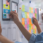Çalışma masasında post-it’lere notlar yapıştırılmış, planlama ve fikirlerin organize edildiği bir çalışma alanı