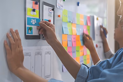 Çalışma masasında post-it’lere notlar yapıştırılmış, planlama ve fikirlerin organize edildiği bir çalışma alanı