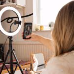 Tripod ile selfie çekmekte olan kadın, YouTube video çekimi için hazırlık yapıyor