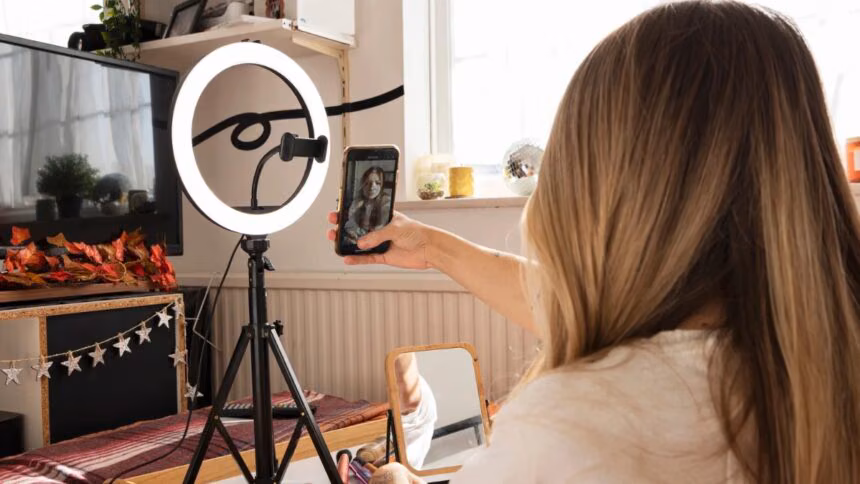 Tripod ile selfie çekmekte olan kadın, YouTube video çekimi için hazırlık yapıyor